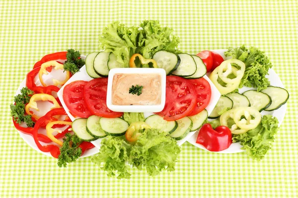 Verduras picadas y salsa en plato sobre mantel verde — Foto de Stock