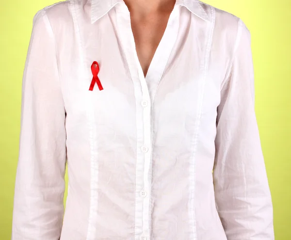 Mujer con cinta roja sobre camisa blanca sobre fondo verde —  Fotos de Stock