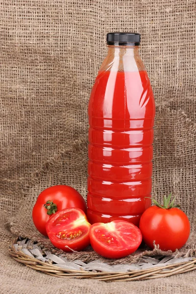 Jus de tomate en bouteille sur fond de sac — Photo