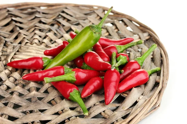 Little hot peppers on wicker mat isolated on white — Stock Photo, Image