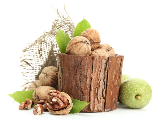 Nueces con hojas verdes en jarrón de madera, aisladas en blanco — Foto de Stock