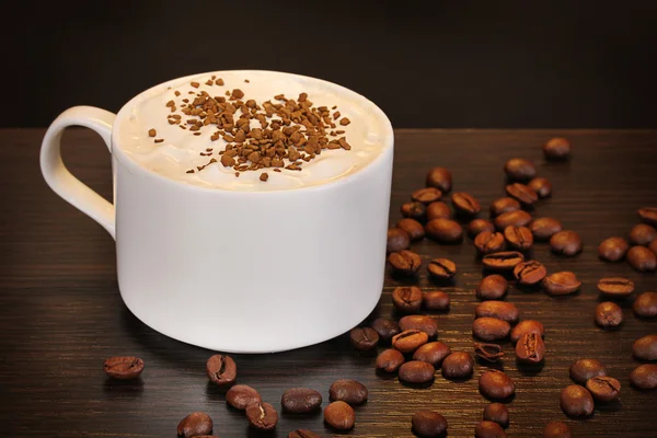 Latte na mesa de madeira no fundo marrom — Fotografia de Stock