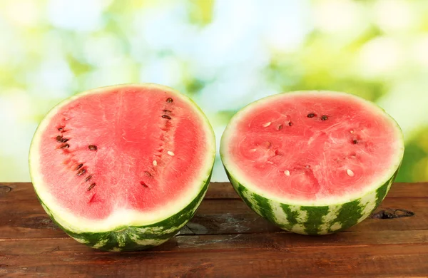 Halves of juicy watermelon on green background close-up — Stock Photo, Image