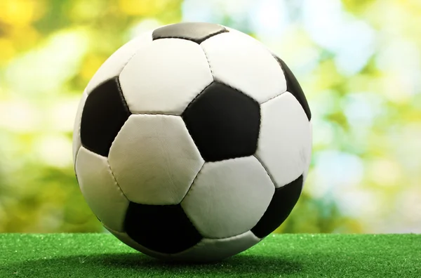 Football ball on artificial green grass — Stock Photo, Image