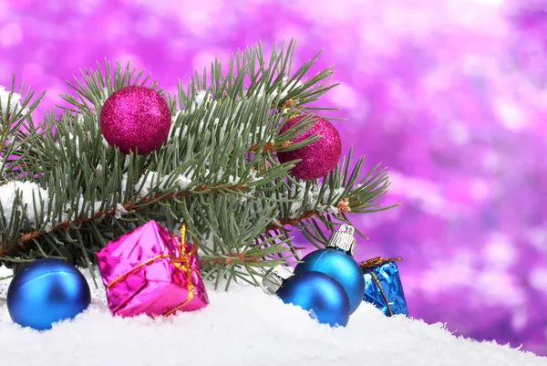 Christmas ball and toy with green tree in the snow on purple — Stock Photo, Image