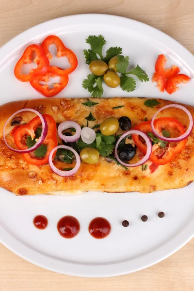 Вкусный кусок пиццы на тарелке с ингредиентами вокруг крупным планом на дереве — стоковое фото