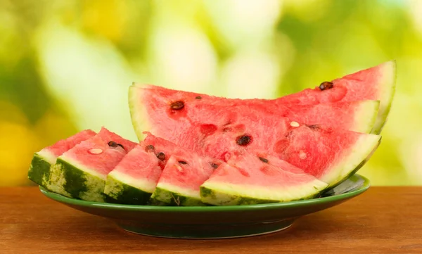 Slices of watermelon on the plate on green background close-up — Stock Photo, Image