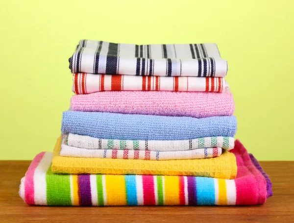 Kitchen towels on wooden table on green background close-up — Stock Photo, Image