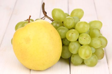 Olgun tatlı üzüm ve elma ahşap zemin üzerinde