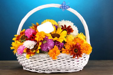 güzel ahşap masa mavi üzerine beyaz sepet içinde parlak çiçek buketi