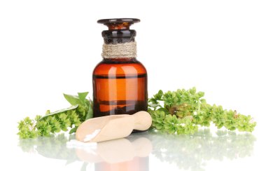 tabletler ve üzerinde beyaz izole çiçeklerle ilaç şişesi