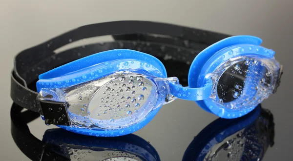 Gafas de baño azul con gotas sobre fondo gris — Foto de Stock