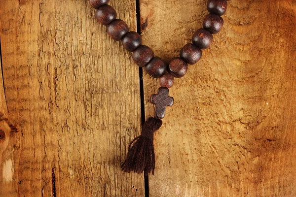 Manik-manik kayu rosario pada latar belakang kayu close-up — Stok Foto