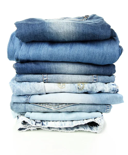 Un sacco di diversi blue jeans isolati su bianco — Foto Stock