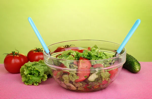 Fresh salad with tomatoes and cucumbers on green background — Stock Photo, Image