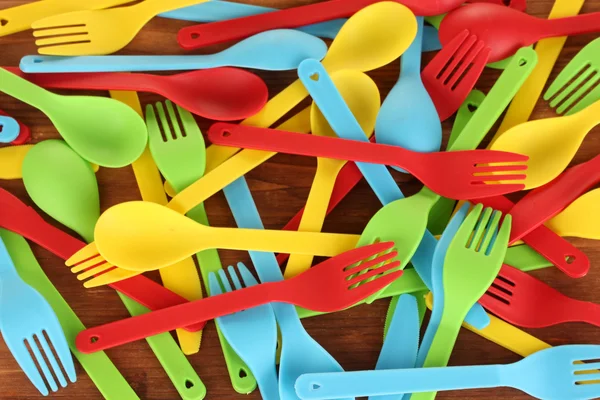 クローズ アップ木製の背景に明るいプラスチックの使い捨て食器 — ストック写真