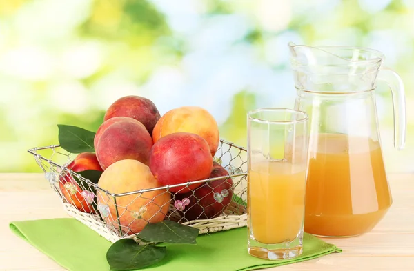 Mogna persikor och juice på träbord på naturliga bakgrund — Stockfoto