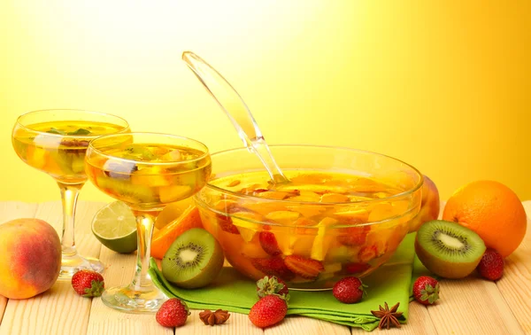 Soco em tigela e copos com frutas, na mesa de madeira, no backgroun amarelo — Fotografia de Stock