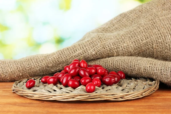 Fresh cornel berries on wicker mat close-up — Stock Photo, Image