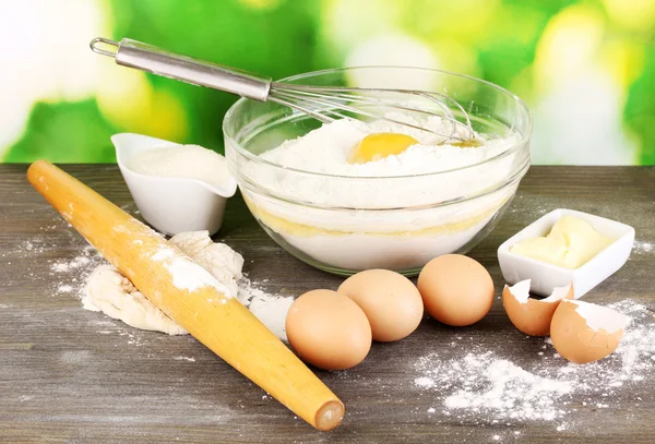 Eggs, flour and butter close-up on wooden table on natural background — Stock Photo, Image