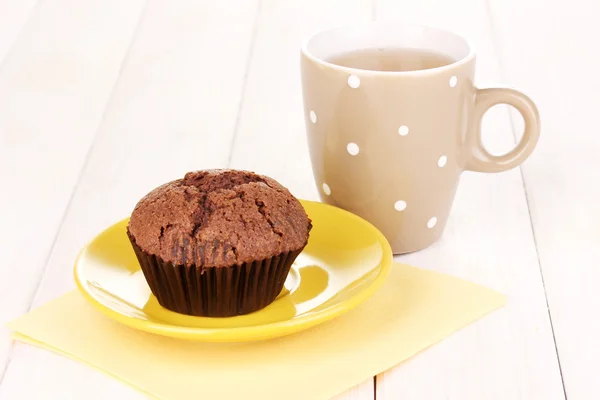 Färska muffin med te på trä bakgrund — Stockfoto