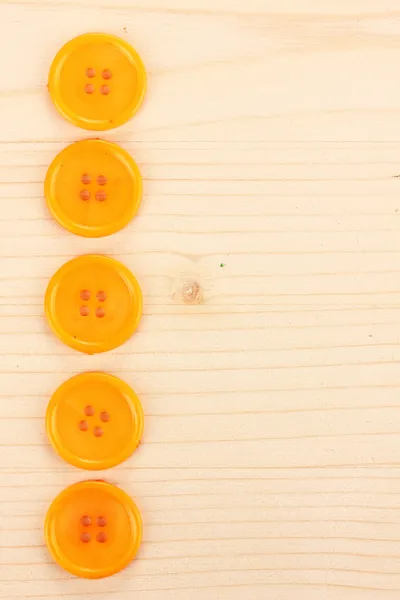 Botões de costura coloridos no fundo de madeira — Fotografia de Stock