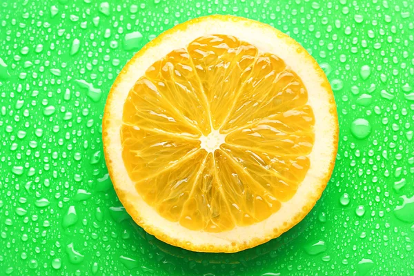 Rebanada de naranja con gota sobre fondo verde — Foto de Stock