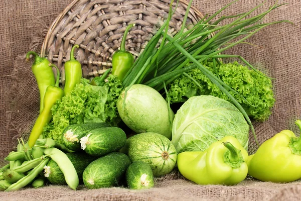 Legumes verdes frescos no fundo pano de saco — Fotografia de Stock