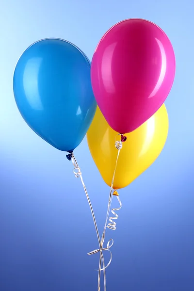 Trois ballons colorés sur fond bleu — Photo