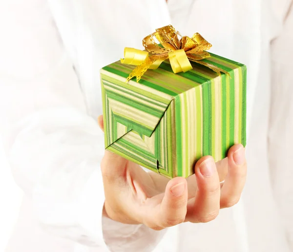 Woman holds a box with a gift on white background close-up — Stock Photo, Image