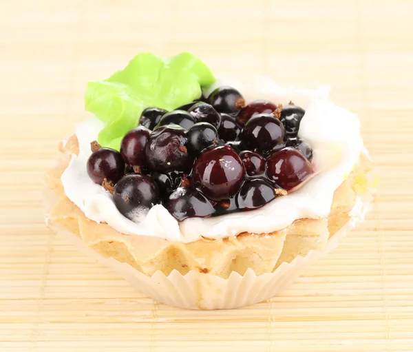 Sweet cake with berries on bamboo mat — Stock Photo, Image