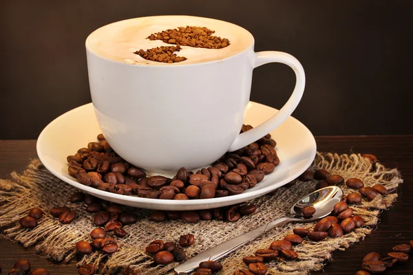 Latte on wooden table on brown background — Stock Photo, Image