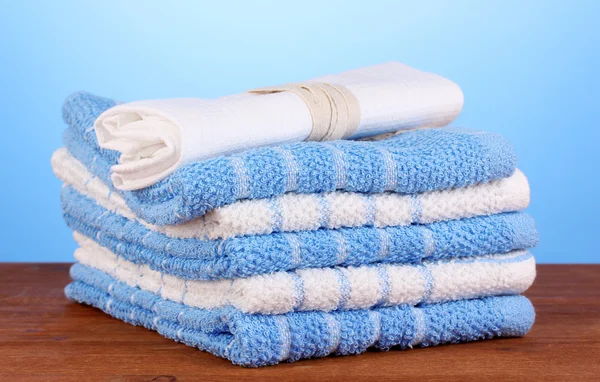 Kitchen towels on wooden table on blue background close-up — Stock Photo, Image