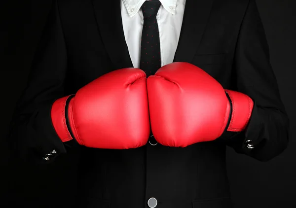 Hombre de negocios en guantes de boxeo aislados en negro —  Fotos de Stock