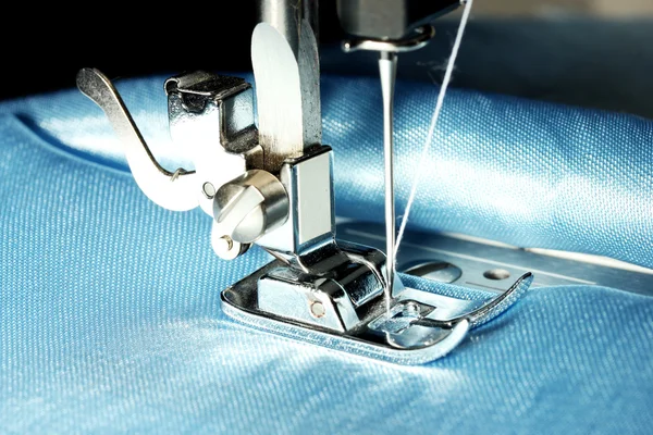 Sewing machine with blue cloth closeup Royalty Free Stock Images