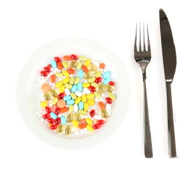 çok fazla hap bir plaka üzerinde beyaz izole çatal ve bıçak