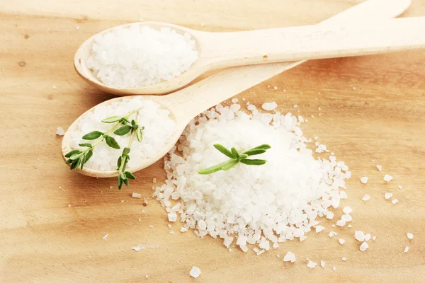 Zout in lepels met verse rozemarijn en tijm op houten achtergrond — Stockfoto