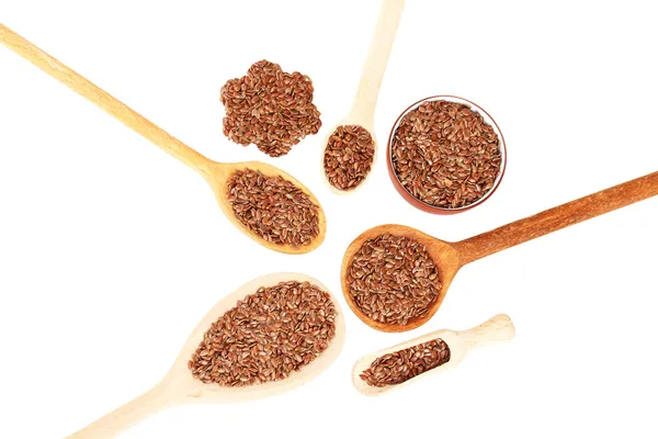 Flax seeds in wooden spoons on white background close-up — Stock Photo, Image
