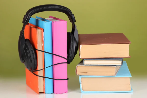 Auriculares en libros sobre fondo verde —  Fotos de Stock