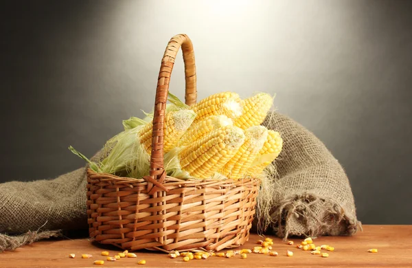 Färsk majs i korg, på träbord, på grå bakgrund — Stockfoto