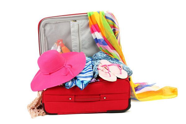 Suitcase with summer clothes, a hat and suntan isolated on white