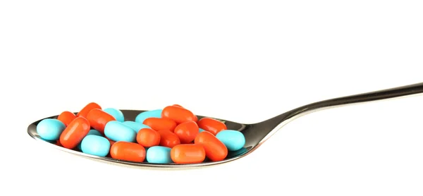 Pílulas coloridas na colher no fundo branco close-up — Fotografia de Stock