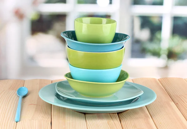 Blue and green tableware on wooden table on window background — Stock Photo, Image