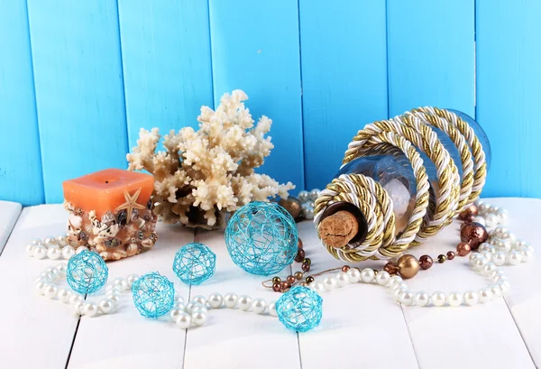 Decor of seashells on wooden table on blue wooden background — Stock Photo, Image