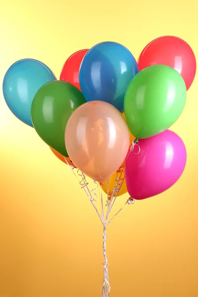 Kolorowe balony na żółtym tle — Zdjęcie stockowe