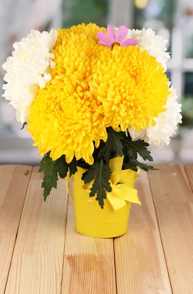 Beautiful chrysanthemum in pail on wooden table on window background — Stock Photo, Image