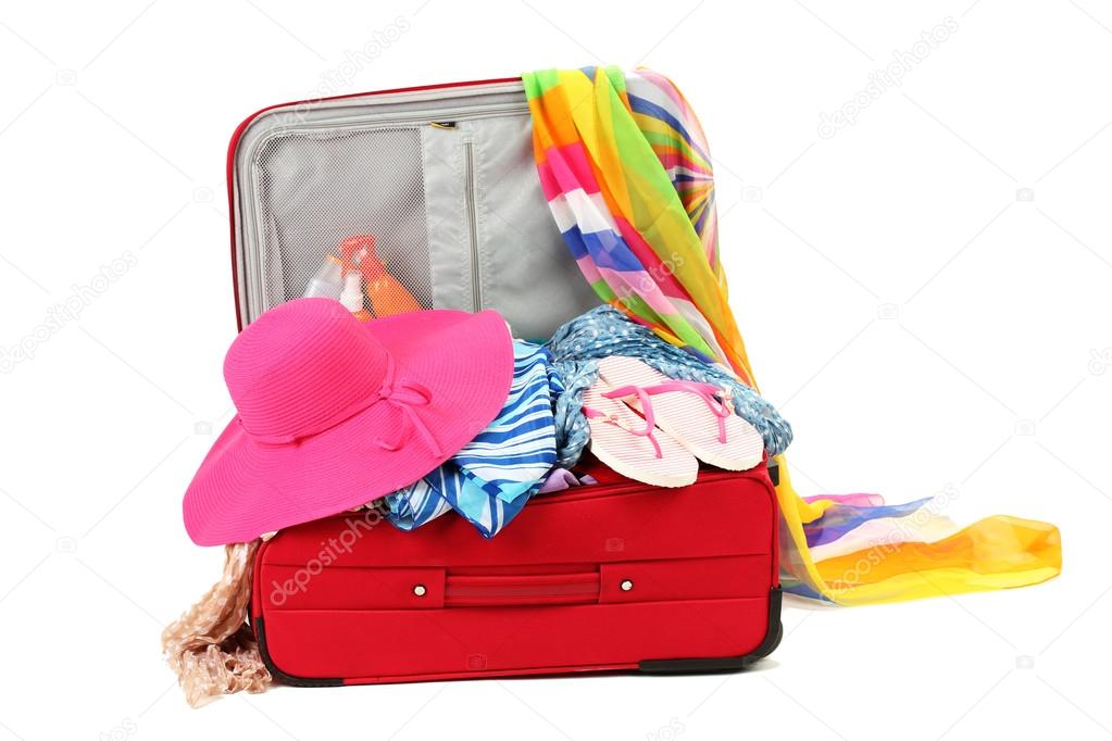 Suitcase with summer clothes, a hat and suntan isolated on white