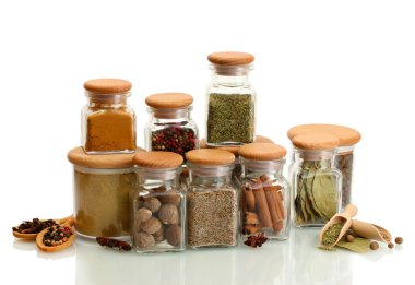 Kavanozlar ve tahta kaşıklar üzerinde beyaz izole baharatlar ile