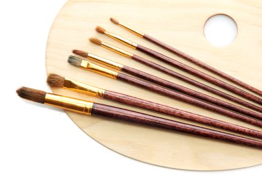 ahşap sanat paleti ve üzerinde beyaz izole fırçalar