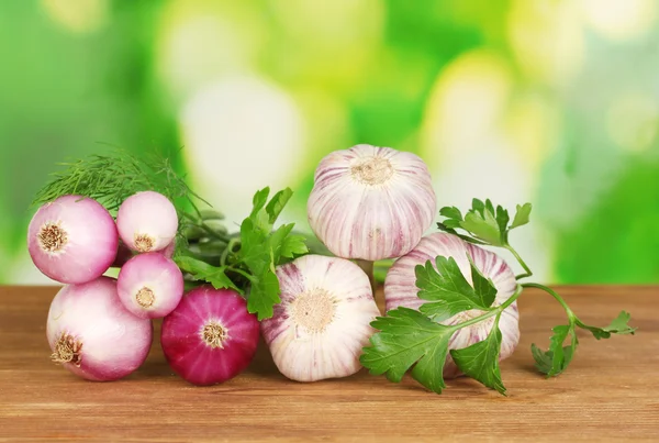 Junger Knoblauch und Zwiebeln auf Holztisch auf hellgrünem Hintergrund Nahaufnahme — Stockfoto